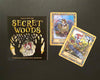 A box labeled Secret Woods by Schiffer Publishing, Ltd. sits on a dark surface next to two illustrated cards—Collector with a badger and Messenger with a fox on a bicycle—from this enchanting intuition card deck.