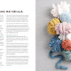 Soft, chunky pastel yarns are arranged on light gray fabric beside a page from "Get Started in Finger Knitting" by Schiffer Publishing, Ltd., showcasing tools and materials for hand-knitting projects.