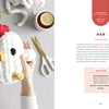 A person holds a plush, white crocheted hen beside chunky yarn, tea, and scissors on a light surface, creating a cozy scene with "Get Started in Finger Knitting" by Schiffer Publishing, Ltd.