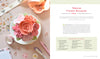 A pastel pink teacup with lifelike felt flowers sits on a saucer by scattered stationery—perfect inspiration from "HeartFELT Crafts to Make and Give" by Schiffer Publishing, Ltd. for beginner crafters or handmade home decor.