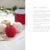 A photo showcases Cozy Christmas Crochet by Schiffer Publishing, Ltd.: cream, gold, and pink thread balls, red ribbon spool, embroidery scissors, and a needle on white. Blurred lit green branches add a hygge holiday crafts vibe; text appears to the right.