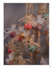 A decorative display for "Wood Turning, from Tree to Table" by Schiffer Publishing, Ltd. features spindles and colorful ornaments with gold and white ribbon bows on a gold stand, set against a gray background.