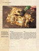 A hand uses a brush to apply gold leaf onto an ornate raised surface, with loose gold flakes nearby. The textured background shows text about the history of gold and gilding techniques from "GOLD" by Schiffer Publishing, Ltd.