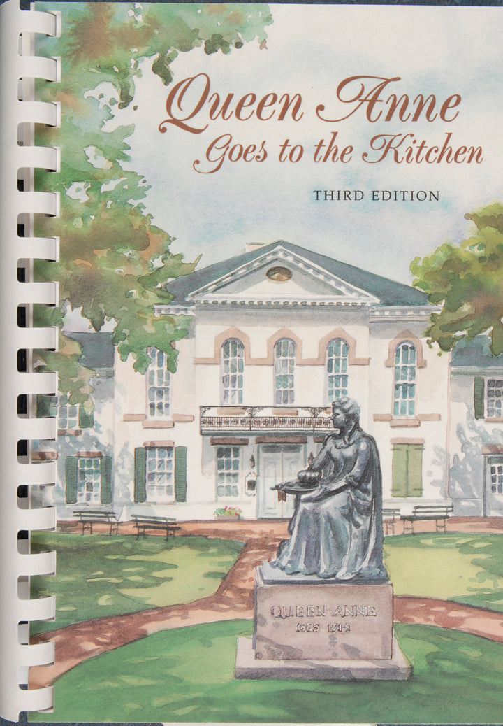 Cover of Queen Anne Goes to the Kitchen by Schiffer Publishing, Third Edition, depicting a stately building, Queen Anne statue, trees, and benches—reflecting regional ingredients in this classic tidewater cookbook.