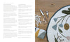An open book, "Rug Hooking with Wool Strips" by Schiffer Publishing, Ltd., displays supplies and tips. Nearby: a floral rug, thread, scissors, hook tool, and towel—ideal inspiration for modern crafters or punch needle enthusiasts.